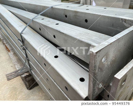 Metal structures for construction and pipes on pallets in an open-air storage warehouse for the storage of materials and industrial equipment Metal structures for construction and pipes on pallets in an open-air storage warehouse for the storage of materials and industrial equipment 95449376