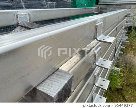 Metal structures for construction and pipes on pallets in an open-air storage warehouse for the storage of materials and industrial equipment 95449377