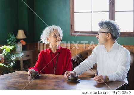 Gray-haired couple drinking espresso 95450250