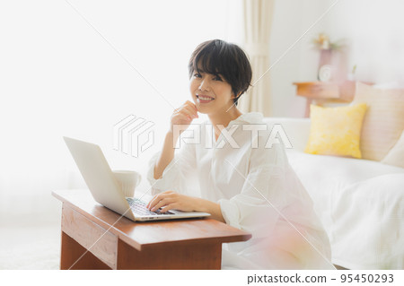 A woman looking at a computer in the living room A woman looking at a computer in the living room 95450293