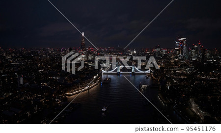 Aerial view to the illuminated Tower Bridge and skyline of London, UK, just after sunset at night time. Aerial view to the illuminated Tower Bridge and skyline of London, UK, just after sunset at night time. 95451176