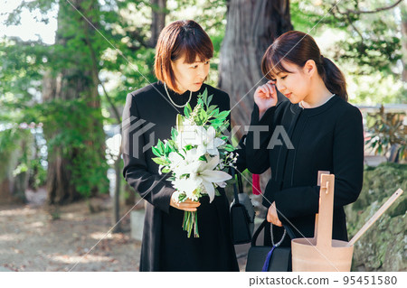 日本婦女在葬禮上安慰喪親的家人 日本婦女在葬禮上安慰喪親的家人 95451580