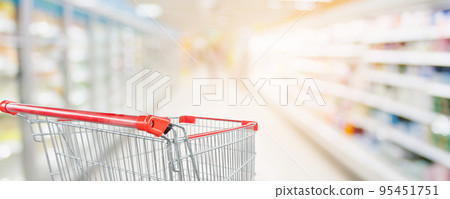 Supermarket aisle blur defocused background with empty red shopping cart Supermarket aisle blur defocused background with empty red shopping cart 95451751
