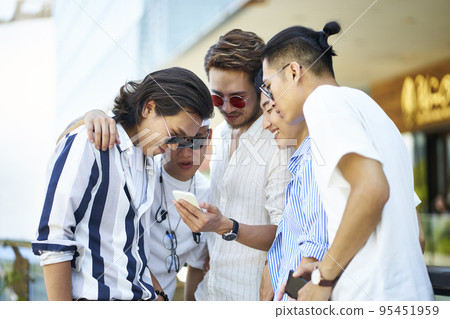 young asian adult men using social media looking at mobile phone together young asian adult men using social media looking at mobile phone together 95451959