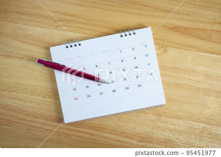Calendar page with pen on wooden desk table 95451977