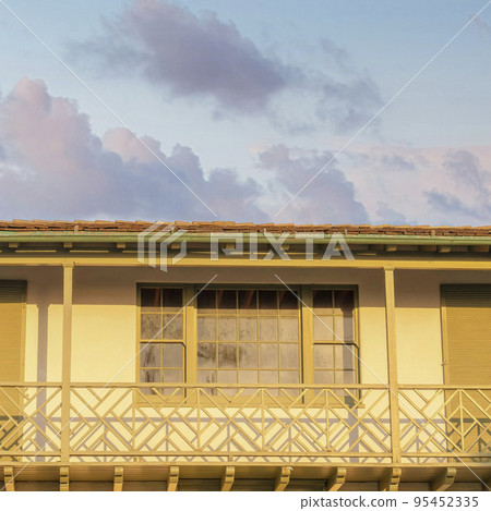 Square Puffy clouds at sunset Low angle view of a balcony with two double doors and shutters a 95452335