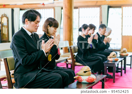 Bereaved family attending the funeral (gassho) 95452425
