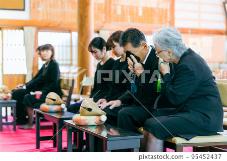 Bereaved family crying at funeral Bereaved family crying at funeral 95452437
