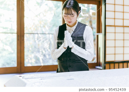 Funeral staff wearing Buddhist garments (Nōkanshi / Gassho) 95452439