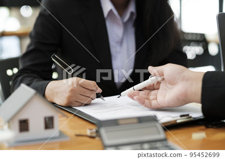 Real estate agent discussing and explaining insurance contract signing to client. 95452699