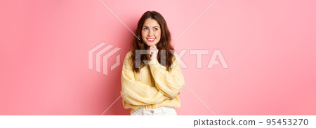Hmm very interesting. Thoughtful young beauty girl looking aside at logo, reading promotional text and thinking, smiling pleased, pink background 95453270
