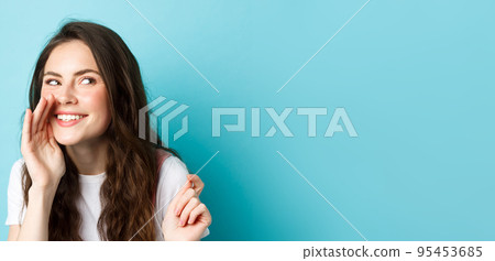 Cunning silly woman spread gossips, talking quiet, telling rumour, smiling and giggle at right side, standing over blue background 95453685