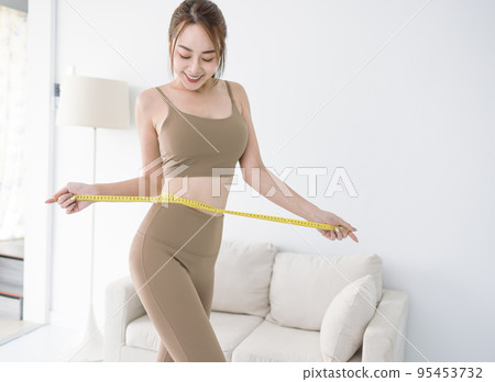 young Asian lady  sportswear measuring waist tape 95453732
