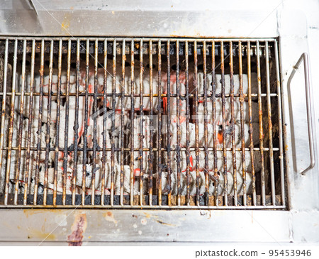Old metal grill on a grill covered with charcoal ash Old metal grill on a grill covered with charcoal ash 95453946