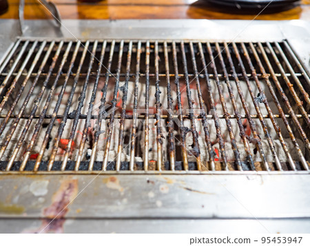 Old metal grill on a grill covered with charcoal ash Old metal grill on a grill covered with charcoal ash 95453947