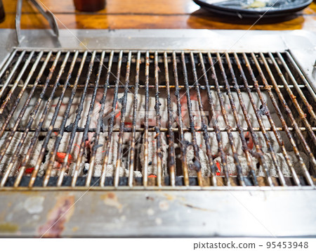 Old metal grill on a grill covered with charcoal ash Old metal grill on a grill covered with charcoal ash 95453948