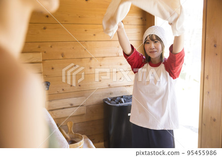 Female heat wave master working in sauna 95455986