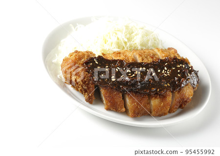 Pork cutlet and shredded cabbage with miso-based sauce photographed against a white background Pork cutlet and shredded cabbage with miso-based sauce photographed against a white background 95455992