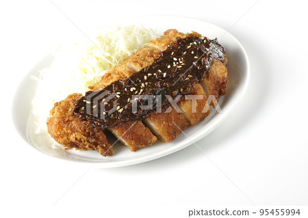 Pork cutlet and shredded cabbage with miso-based sauce photographed against a white background 95455994