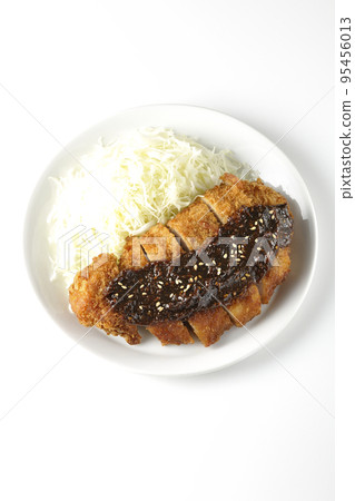 Overhead shot of shredded pork cutlet and cabbage with miso-based sauce on white background 95456013