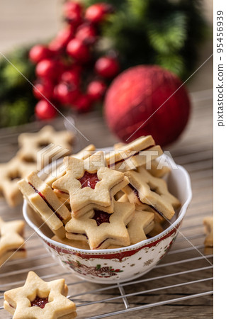 Holiday pastries Linz cookies in the shape of stars in a Christmas bowl 95456939