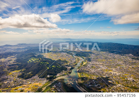 從和歌山縣紀之川市的百合山上空乘坐滑翔傘鳥瞰岩出市和和歌山市。陽光明媚的十月 從和歌山縣紀之川市的百合山上空乘坐滑翔傘鳥瞰岩出市和和歌山市。陽光明媚的十月 95457156