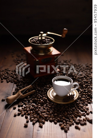 Cup of coffee and beans at wood table. Homemade coffee at table Cup of coffee and beans at wood table. Homemade coffee at table 95457939