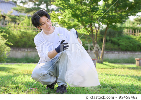 Young man picking up trash volunteer cleaning image 95458462