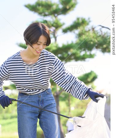 Young woman picking up trash volunteer cleaning image 95458464