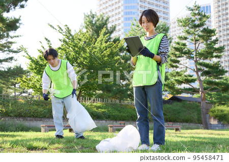 Young men and women picking up trash Volunteer cleaning image Young men and women picking up trash Volunteer cleaning image 95458471