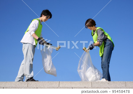 青年男女在陽光明媚的天氣下在戶外撿垃圾志願者清潔形象 95458478