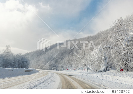 Scenic view of curve turn on beautiful mountain forest cpuntry woods highway road at cold snowy sunny weather winter day. Wintry frosty route landcape. Travel season journey trip drive Scenic view of curve turn on beautiful mountain forest cpuntry woods highway road at cold snowy sunny weather winter day. Wintry frosty route landcape. Travel season journey trip drive 95458762
