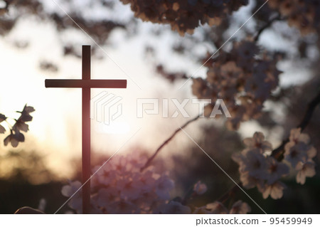 Sunlight shining brightly through the forest trees at sunset, spring flowers and the cross of the resurrection of Jesus Christ 95459949