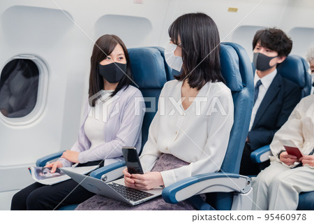 飛機上戴口罩的乘客 飛機上戴口罩的乘客 95460978