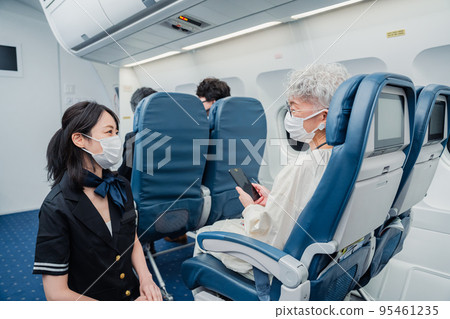 一名戴著口罩並提供機上服務的空乘人員 95461235