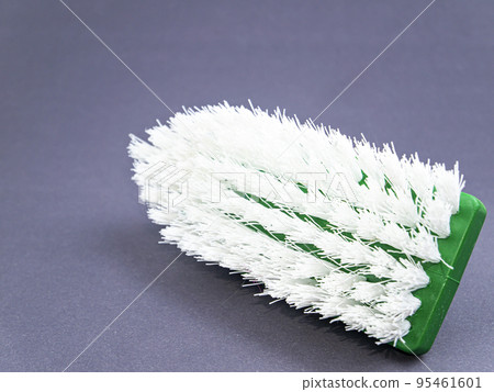 Clothes brush with white bristles on a gray background. Clothes brush with white bristles on a gray background. 95461601