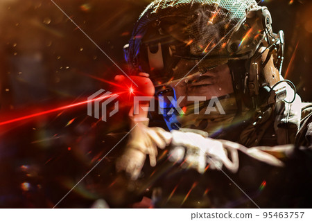 Army soldier in Combat Uniforms with an assault rifle and combat helmet night mission dark background. Blue and purple gel light effect. 95463757