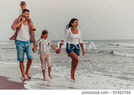 Family gatherings and socializing on the beach at sunset. The family walks along the sandy beach. Selective focus Family gatherings and socializing on the beach at sunset. The family walks along the sandy beach. Selective focus 95463760