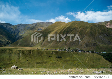 village panorama gorge with green Svaneti nature around in Caucasus mountains and horse riderin the foreground. .Georgia 95464427