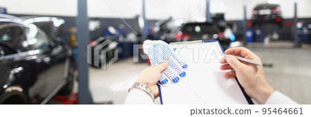 Male worker fill maintenance documentation, view on car garage 95464661