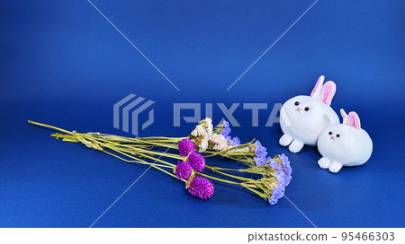 Two cute stuffed rabbits and dried flowers (blue background) 95466303