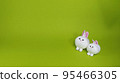 Two cute stuffed rabbits, yellow-green background 95466305