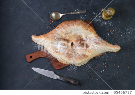 Georgian bread lavash on wooden board on dark rustic background, top view Georgian bread lavash on wooden board on dark rustic background, top view 95466757