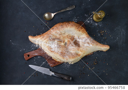 Georgian bread lavash on wooden board on dark rustic background, top view Georgian bread lavash on wooden board on dark rustic background, top view 95466758
