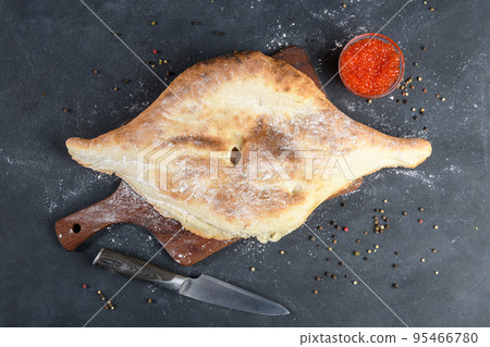 Georgian bread lavash with red caviar on wooden board on dark rustic background, top view Georgian bread lavash with red caviar on wooden board on dark rustic background, top view 95466780