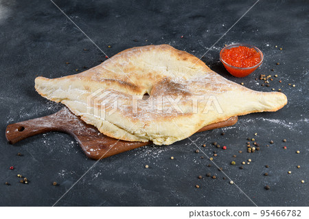 Georgian bread lavash with red caviar on wooden board on dark rustic background, top view Georgian bread lavash with red caviar on wooden board on dark rustic background, top view 95466782
