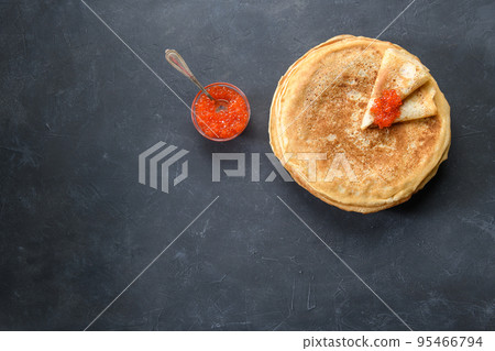 Stack of pancakes with red caviar on dark rustic background, top view 95466794
