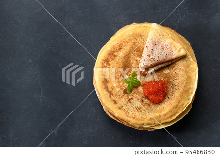 Stack of pancakes with red caviar on dark rustic background, top view with free text space 95466830