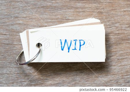 Flash card with handwriting in word WIP (Abbreviation of work in progress)  on wood background 95466922