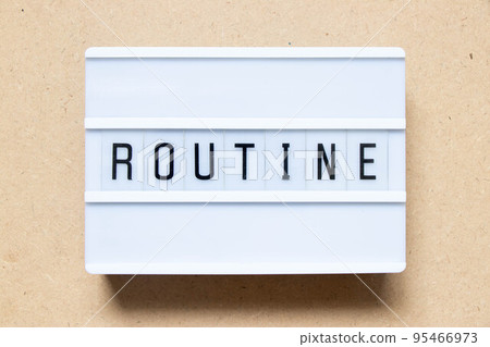 Lightbox with word routine on wood background 95466973